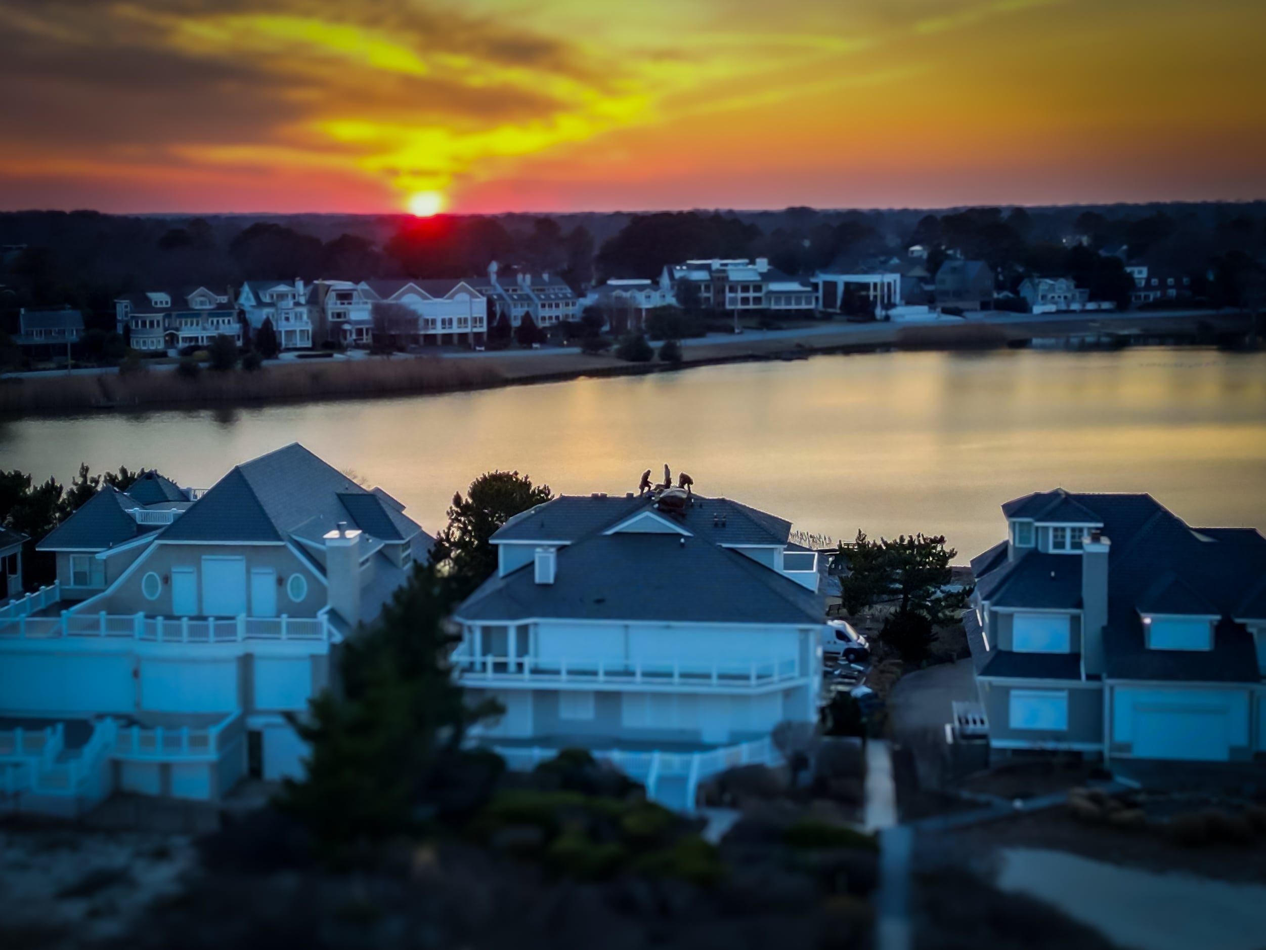 Pro Exteriors roofing crew installs Brava Roof tiles on Rehoboth Beach Delaware home at sunset